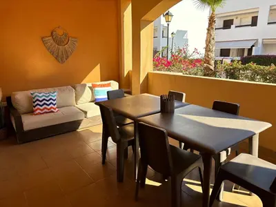 Zona de estar de Bajo con jardín a pie de playa y piscina comunitaria con jacuzzi