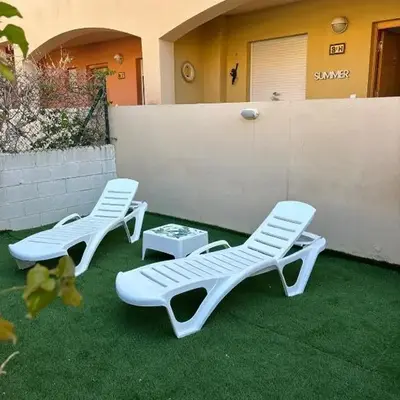Bajo con jardín a pie de playa y piscina comunitaria con jacuzzi