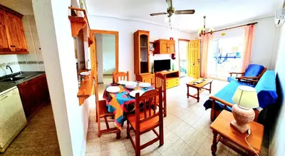 Una televisión o centro de entretenimiento en Apartamento dos dormitorios Veramar 5 1ª línea de playa con vistas al mar