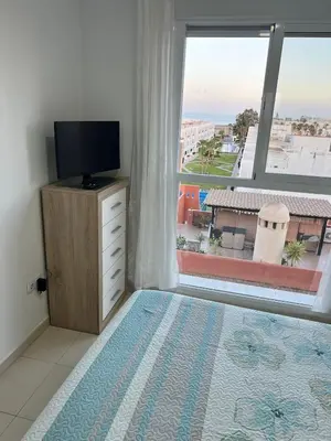 Una televisión o centro de entretenimiento en Ático con vistas al mar y piscina privada