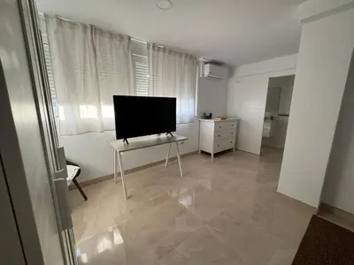 Una televisión o centro de entretenimiento en Tokyo Rooms Los Genoveses Habitacion PREMIUM con baño privado