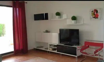 Una televisión o centro de entretenimiento en Apartamento unifamiliar Golf Vera urb privada y tranquila