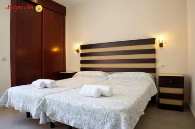 Cama o camas de una habitación en Apartamentos la Buganvilla