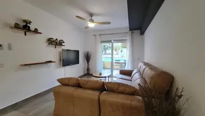Una televisión o centro de entretenimiento en Apartamento con Piscina