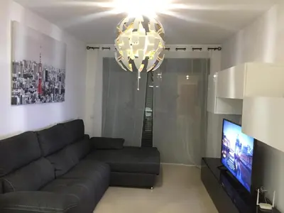 Una televisión o centro de entretenimiento en Apartamento Lujo, Primera linea playa, Garaje, Wifi, Piscina climatizada