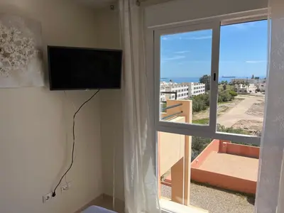 Una televisión o centro de entretenimiento en Atico con piscina privada vistas al mar