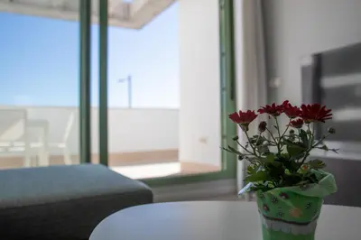 Una televisión o centro de entretenimiento en Precioso apartamento frente a la playa con piscina