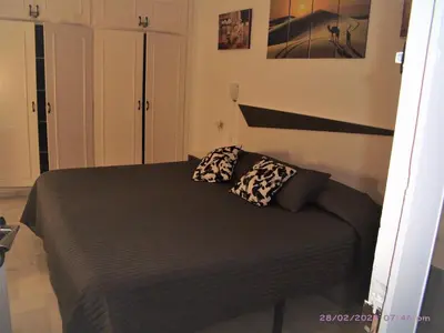 Cama o camas de una habitación en APARTAMENTO BAJO NATURISTA A PIE DE PLAYA.