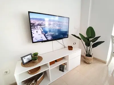 Una televisión o centro de entretenimiento en Avenida Principal - Gran Terraza junto a la playa - by Aloha Palma