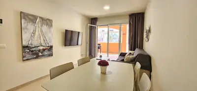 Una televisión o centro de entretenimiento en Homes of Spain, Apartamentos Paraiso de Vera Playa, Ed Tahiti bajo H, a pie de la playa, vistas piscina